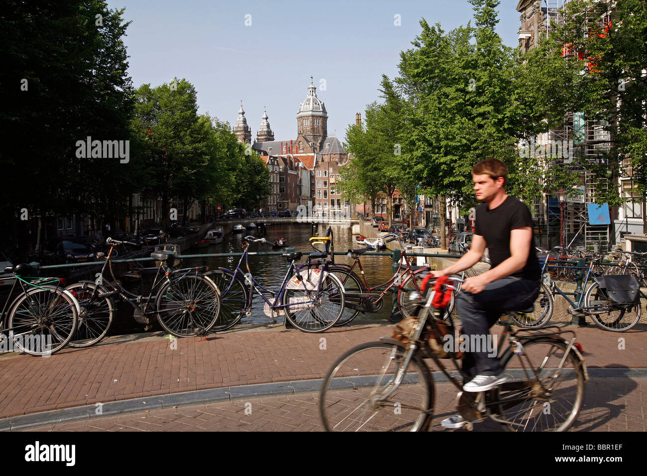 Le biciclette olandesi SU UN CANALE DEL PONTE E SINT NICOLAASKERK CHIESA Foto Stock