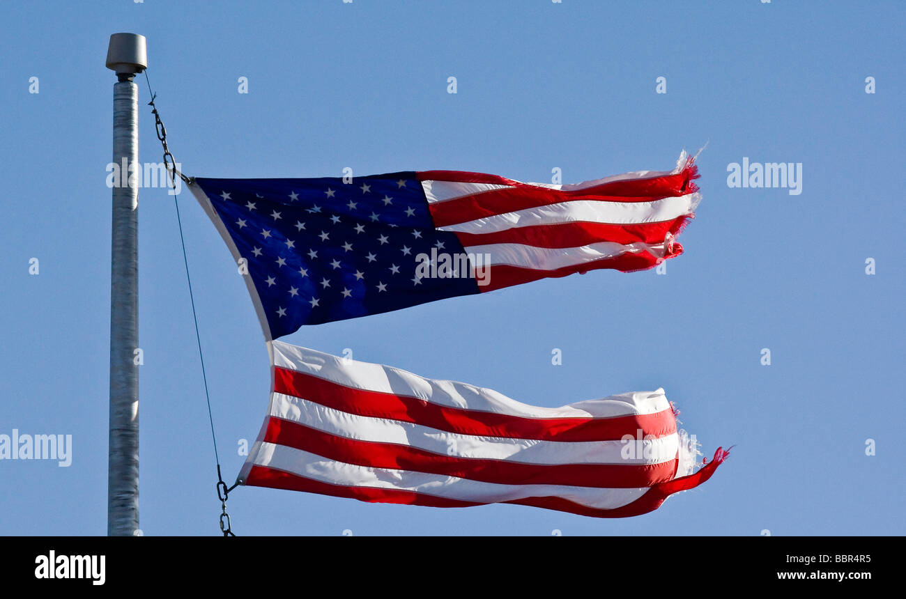 Bandiera americana strappata a metà su un palo di bandiera. Foto Stock