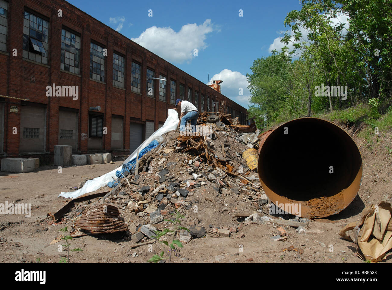 Un uomo copre i detriti da un edificio contenente amianto nel New Haven, Connecticut Foto Stock