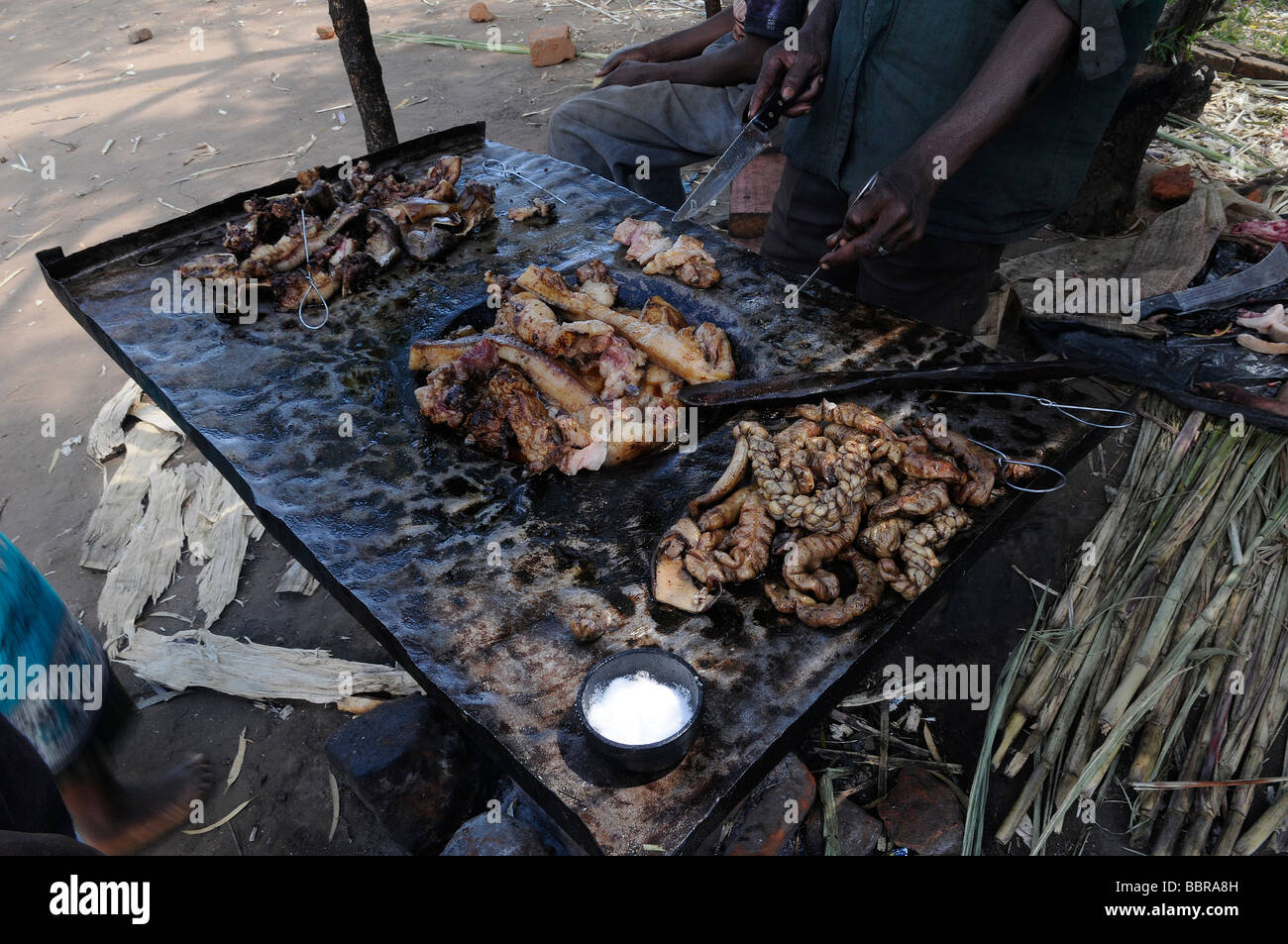 Fornitore preparano grigliate di carne in strada in Malawi in Africa centrale Foto Stock
