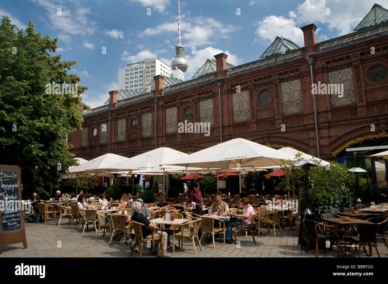 La gente seduta in un ristorante presso la Hackecher Markt rail station Berlino Germania Foto Stock