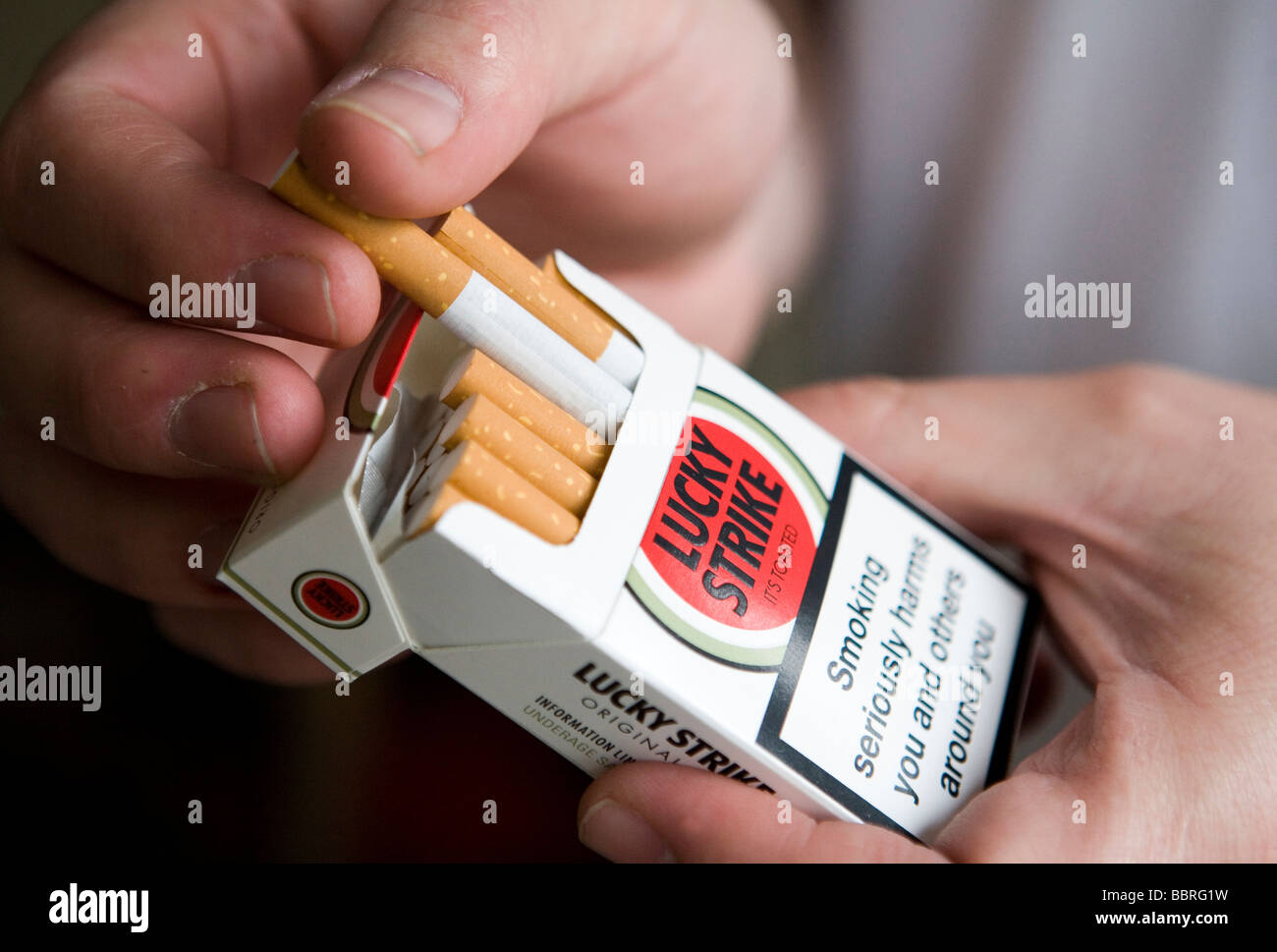 Un fumatore prende un colpo di fortuna sigaretta prodotta dalla British  American Tobacco a partire da un pacchetto Foto stock - Alamy