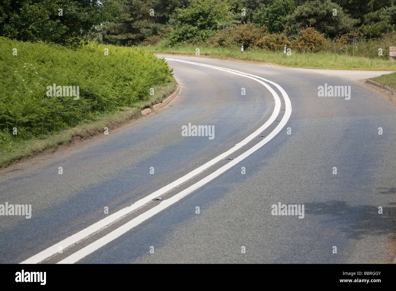 Sharp aveva lasciato piegare in strada con il doppio di linee bianche Foto Stock