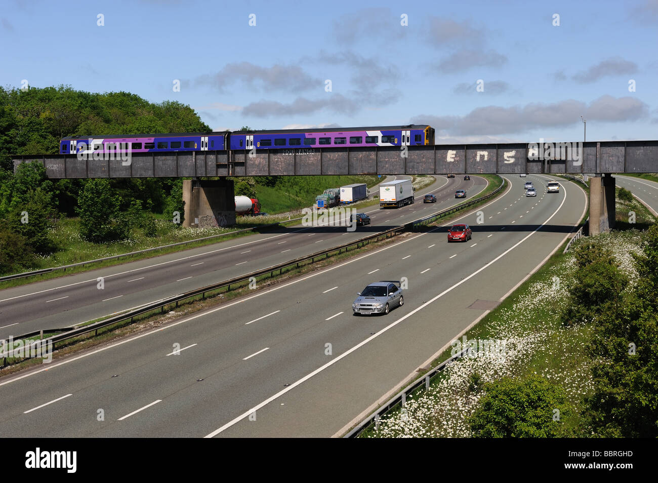 A Sheffield a Huddersfield treni passeggeri attraversa la M1 allo svincolo 37. Foto Stock