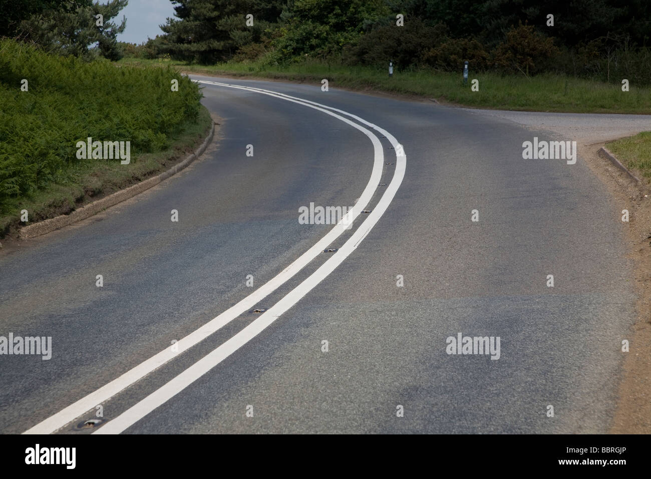 Sharp aveva lasciato piegare in strada con il doppio di linee bianche Foto Stock