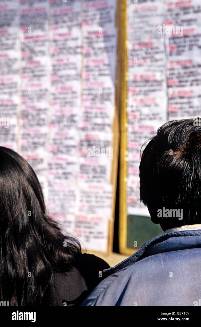 Disoccupati l uomo e la donna che guarda attraverso annunci di lavoro in Huancayo, Perù Foto Stock