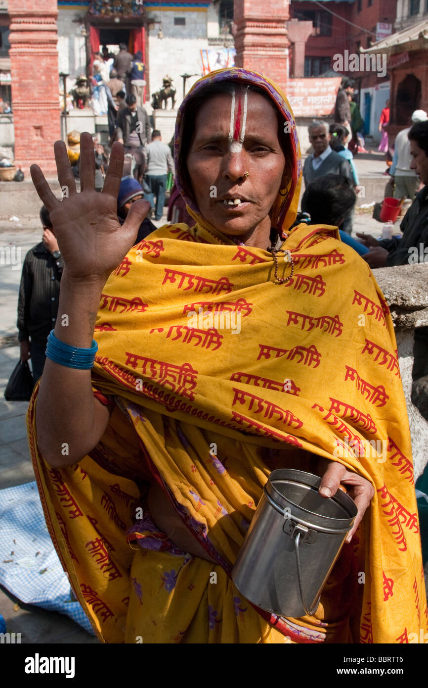 Kathmandu, Nepal. Donna indù cerca alms, indossa tilak sulla fronte un segno di devozione a Vishnu. Facendo gesto di pace. Foto Stock