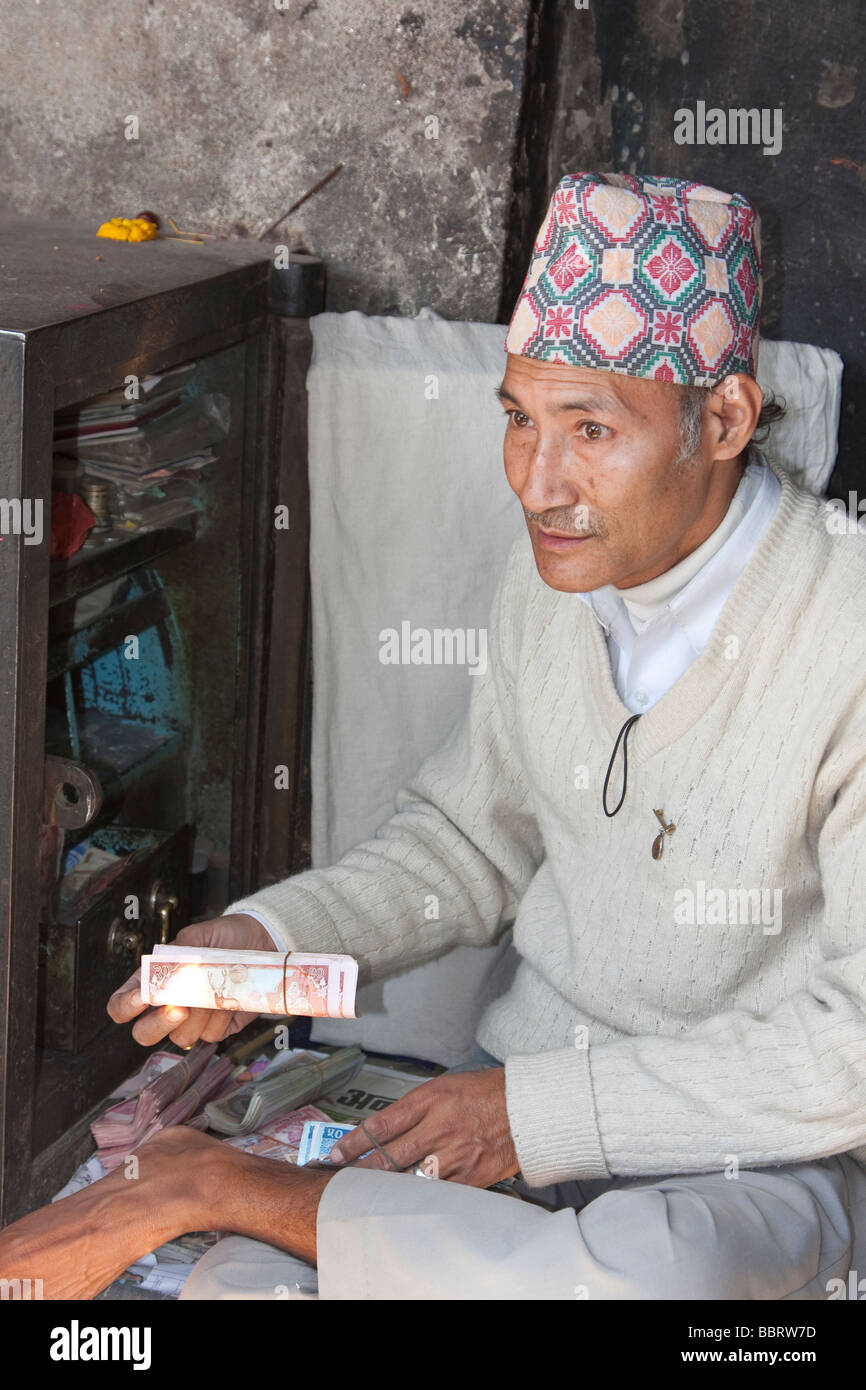 Kathmandu, Nepal. Caricatore di denaro nel mercato, Durbar Square, indossando un Topi, tradizionale il nepalese Hat. Foto Stock