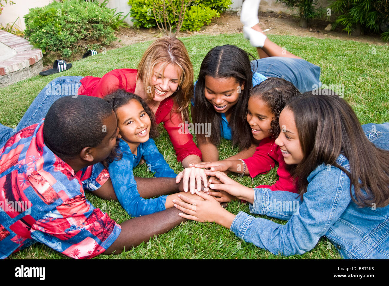 La grande famiglia africana/etnica caucasica famiglia giocando il contatto visivo guardando la telecamera bi razziale diversità biracial diverse interracial signor © Myrleen Pearson Foto Stock