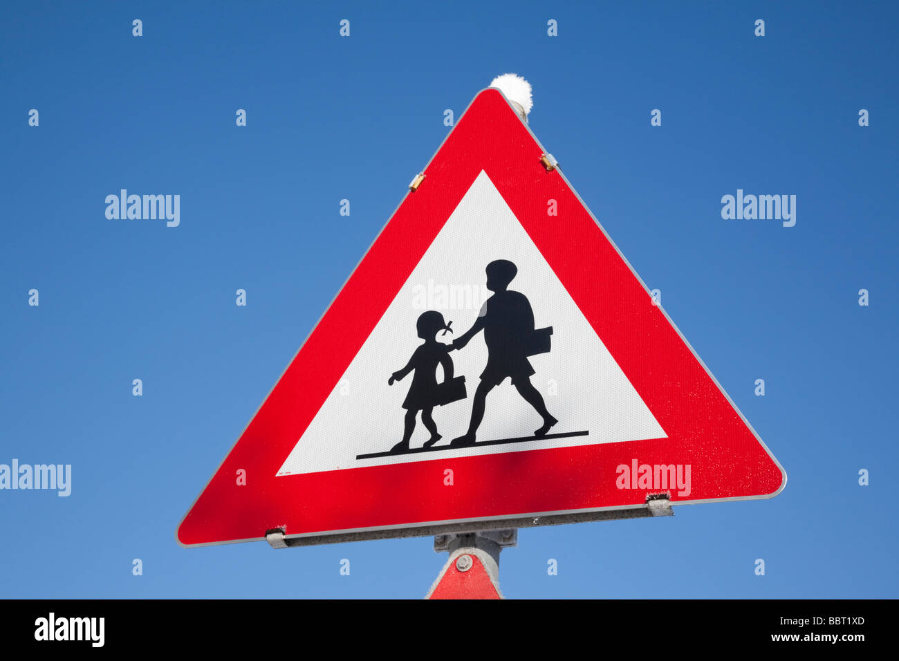 Triangolare segno di avvertimento per i bambini di strada di attraversamento contro il cielo blu sullo sfondo. Regno Unito Gran Bretagna Europa Foto Stock