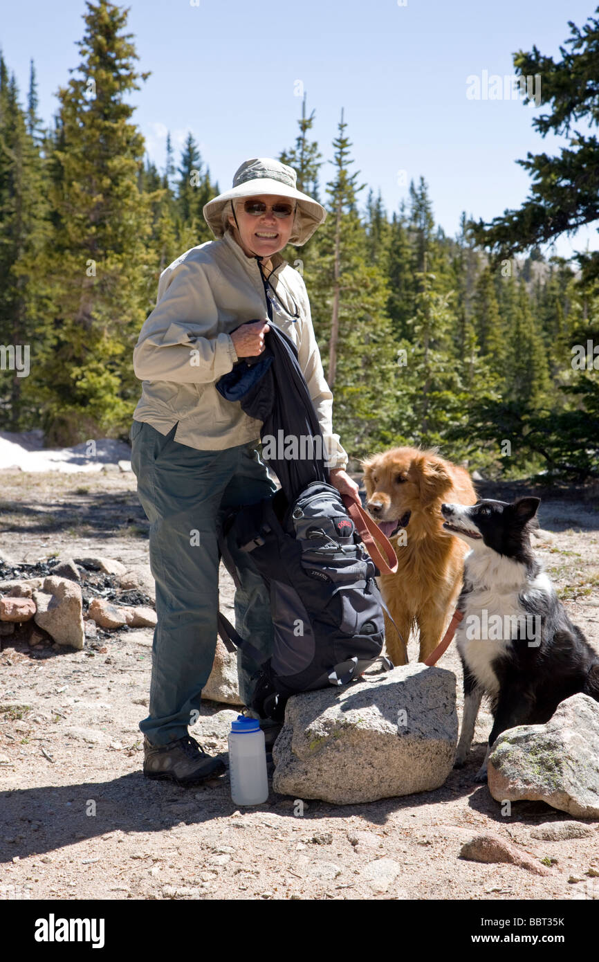 Escursionista femmina al Lago Waterdog Chaffee County Colorado USA ella è accompagnato da un Golden Retriever e Border Collie Foto Stock