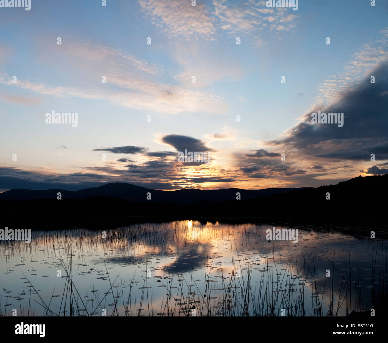 Ancora loch riflessioni a sunrise. Isle of Harris, Ebridi Esterne, Scozia Foto Stock