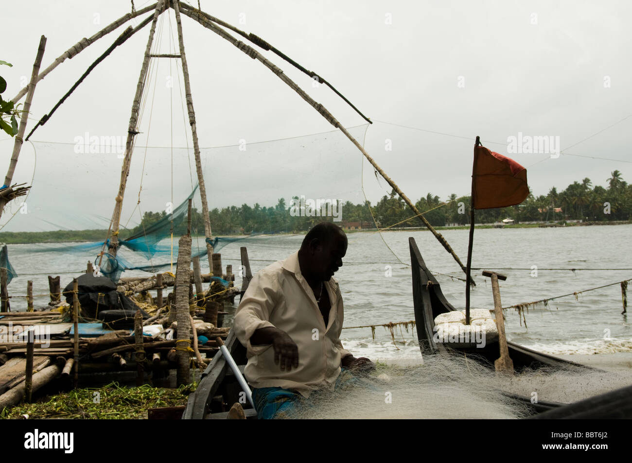 Tribale indiano fisherman riassettando le reti da pesca Foto Stock
