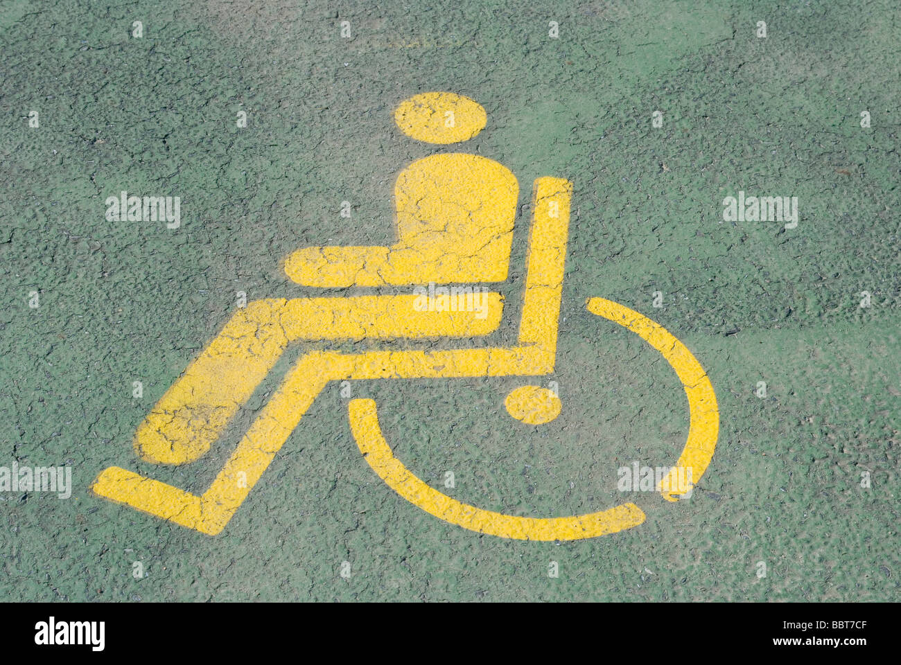 Dipinto di giallo simbolo di Handicap su uno spazio di parcheggio Foto Stock