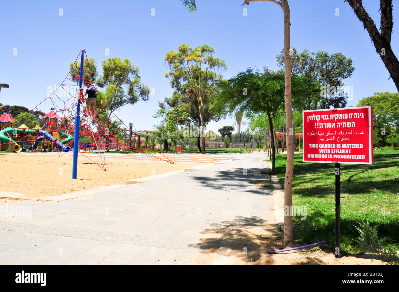 Un segnale di avvertimento in ebraico in arabo e in inglese questo giardino è irrigato con effluente potabile è vietato in un parco Foto Stock