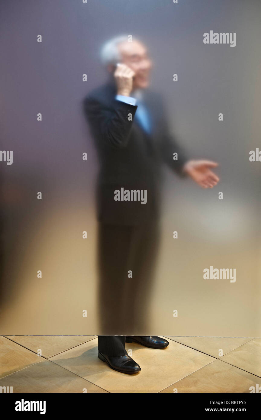 Senior Uomo al telefono dietro lo schermo Foto Stock