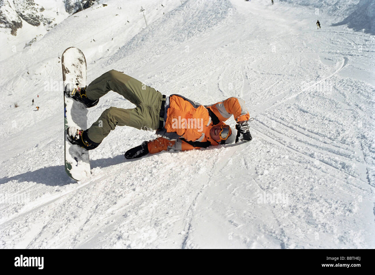 La laminazione del ragazzo in neve con uno scarpone da snowboard Foto Stock