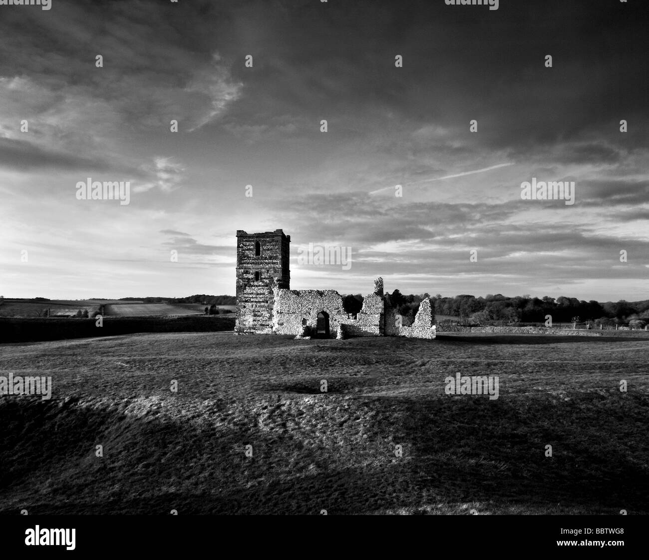 Un bianco e nero studio del drammatico autunno in luce i resti della chiesa medievale di Knowlton, Dorset Foto Stock