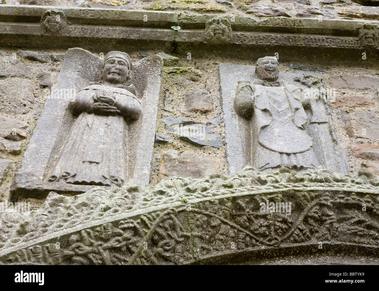 San Francesco e di San Patrizio a Clonmacnoise Cattedrale. Due figure scolpite da questi famosi santi al di sopra di un scolpito del telaio della porta. Foto Stock