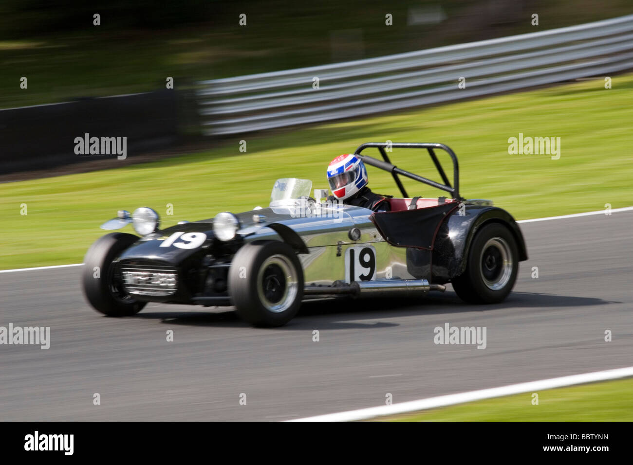 Il panning motion shot di Caterham car racing intorno a via Foto Stock