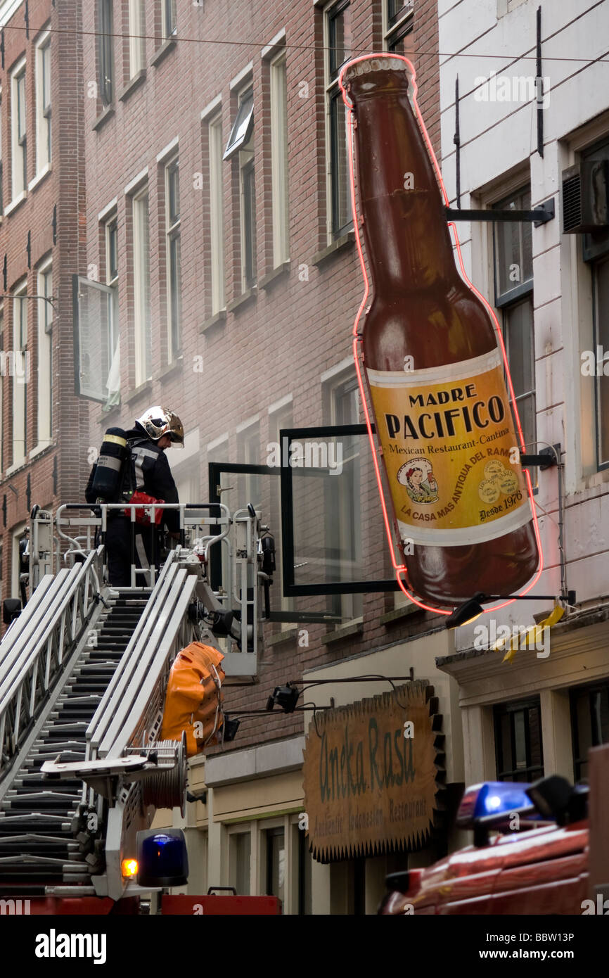 Firefighter ispezionando un incendio nel quartiere a luci rosse di Amsterdam Foto Stock