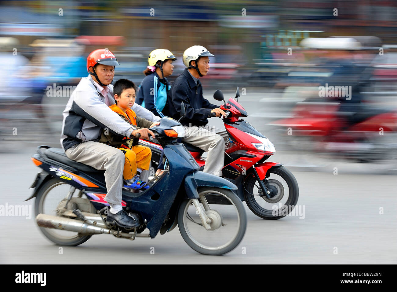 Padre e figlio su un ciclomotore, Hanoi, Vietnam del nord, sud-est asiatico Foto Stock