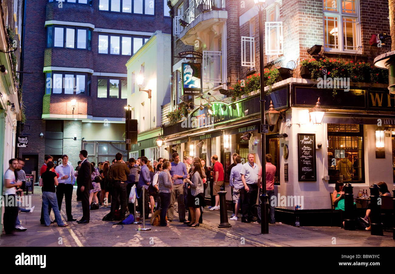 La folla di persone in piedi al di fuori di un pub di Londra in Soho London UK Europa Foto Stock