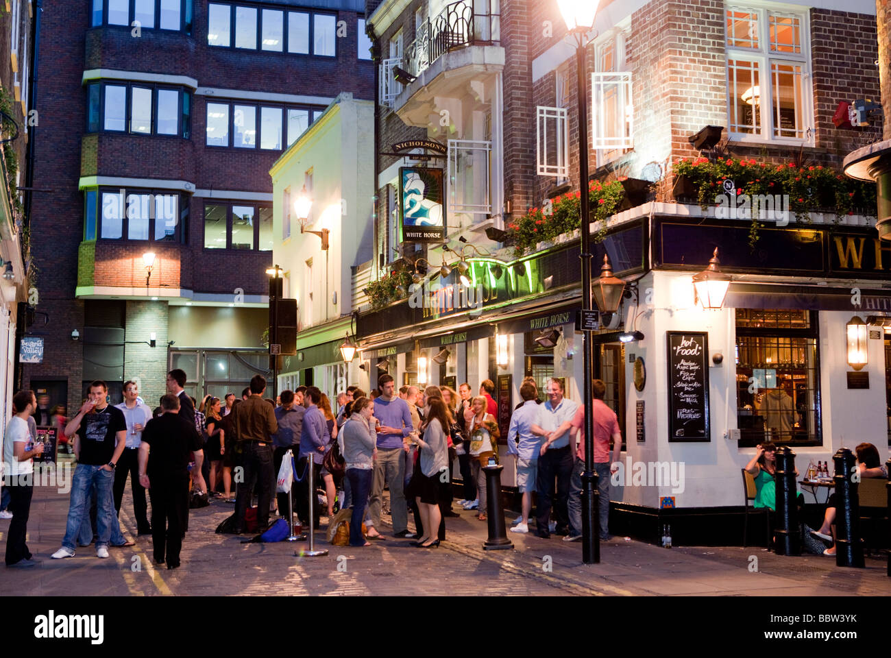 La folla di persone in piedi al di fuori di un pub di Londra in Soho London UK Europa Foto Stock
