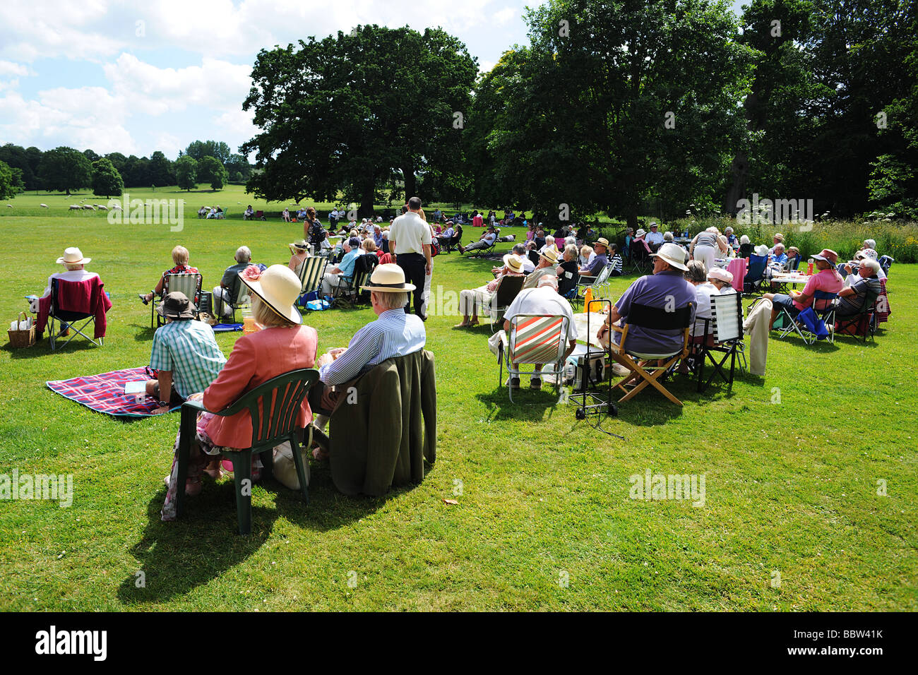 Folla di pubblico con picnic su un prato Ovest Paese Inghilterra in estate il sole Foto Stock