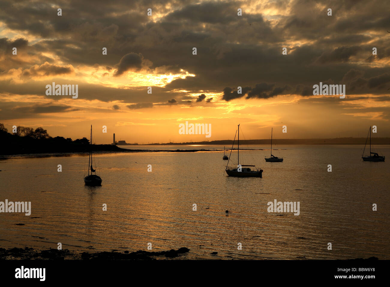 Il tramonto visto dalla riva di caligine, West Lothian guardando ad ovest lungo il fiume Forth. Foto Stock