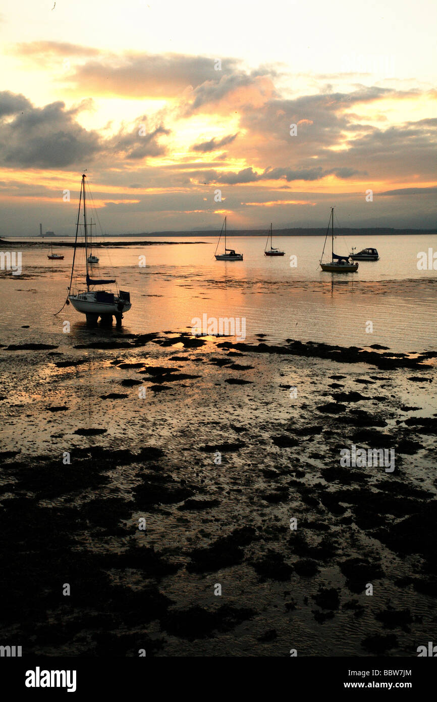 Il tramonto visto dalla riva di caligine, West Lothian guardando ad ovest lungo il fiume Forth. Foto Stock