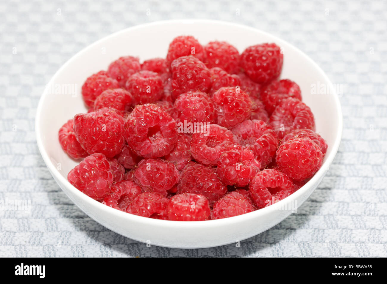 Mature succosa ciotola di estate fresche Lamponi con n. di persone Foto Stock