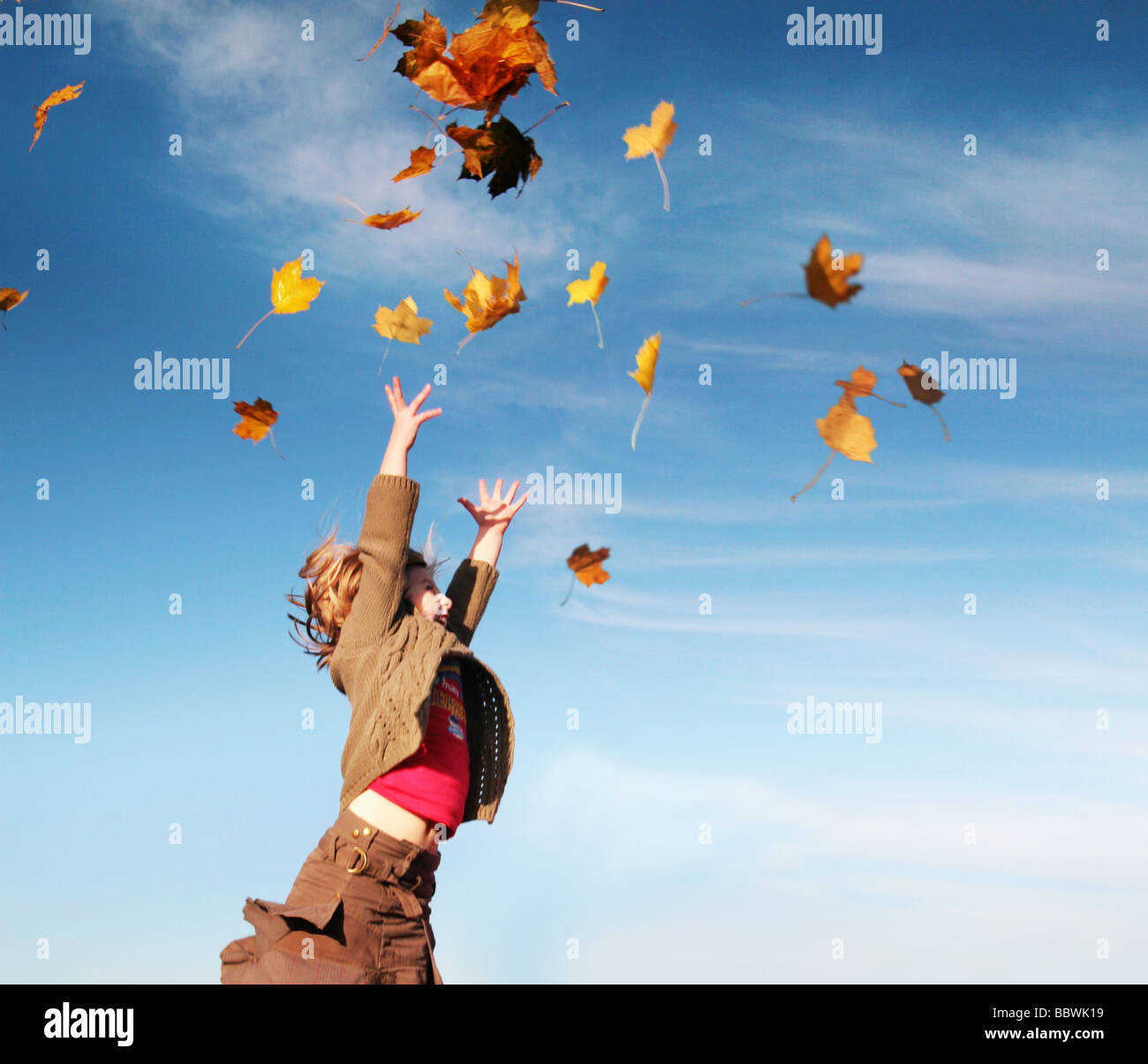 Ragazza cattura le foglie in autunno Foto Stock
