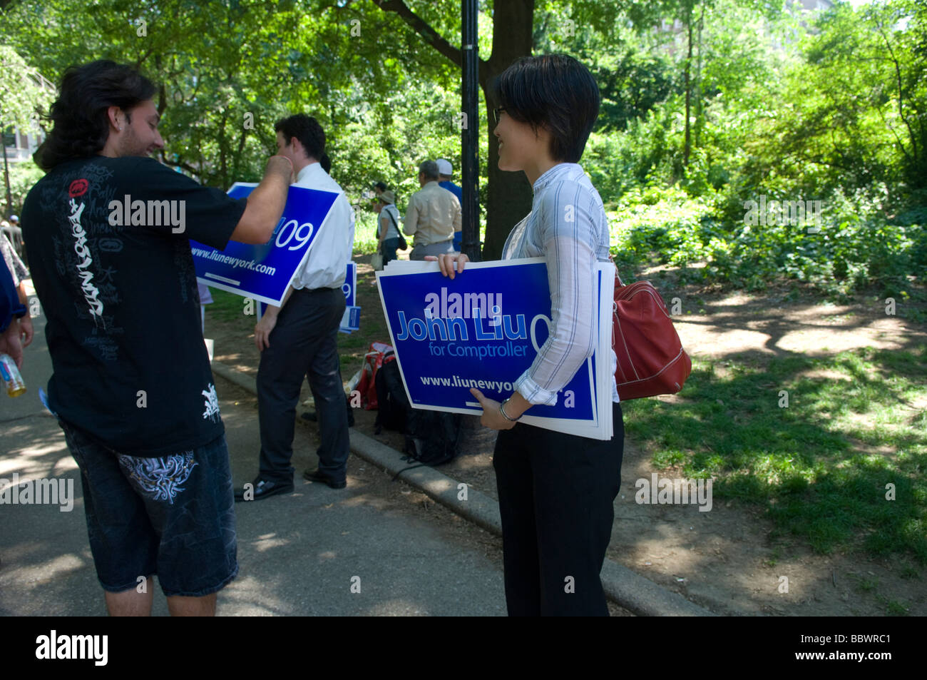 Sostenitori per New York City Councilmember Giovanni Liu passano fuori i manifesti per Giovanni Liu per Comptroller Foto Stock