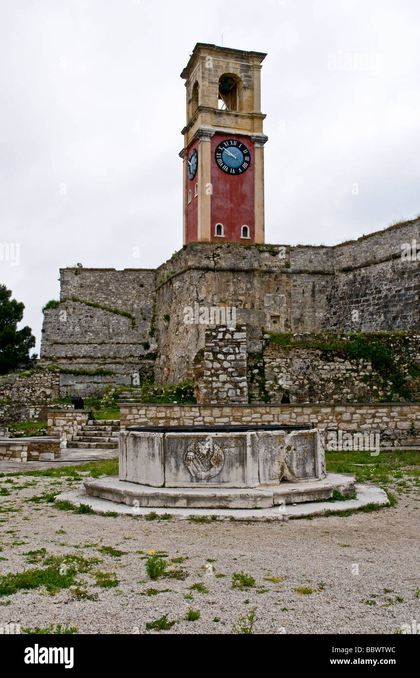 Il rosso orologio in mattoni e torre campanaria protetti dietro le alte mura dentro la Fortezza Vecchia, citta di Corfu Foto Stock