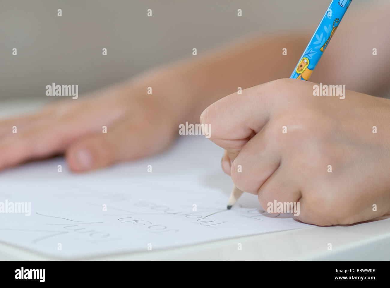 A cinque anni ragazzo caucasico iscritto con carta e matita Foto Stock