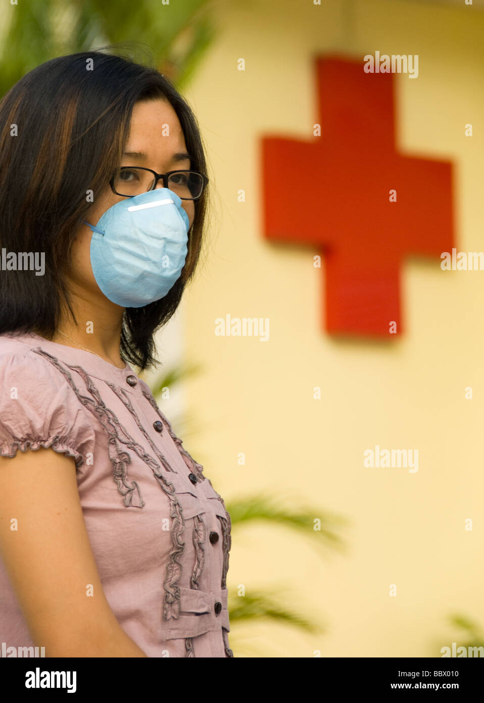 Il vietnamita donna che indossa la maschera per il viso per timore di influenza suina. Foto Stock