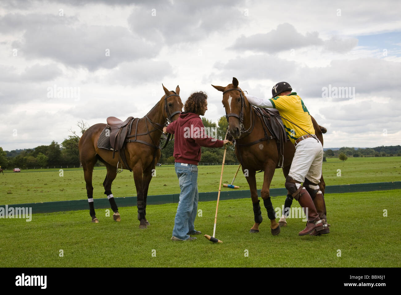 Un giocatore di polo cambia cavalli chukka mid a Cowdray Park, West Sussex, in Inghilterra. Foto Stock