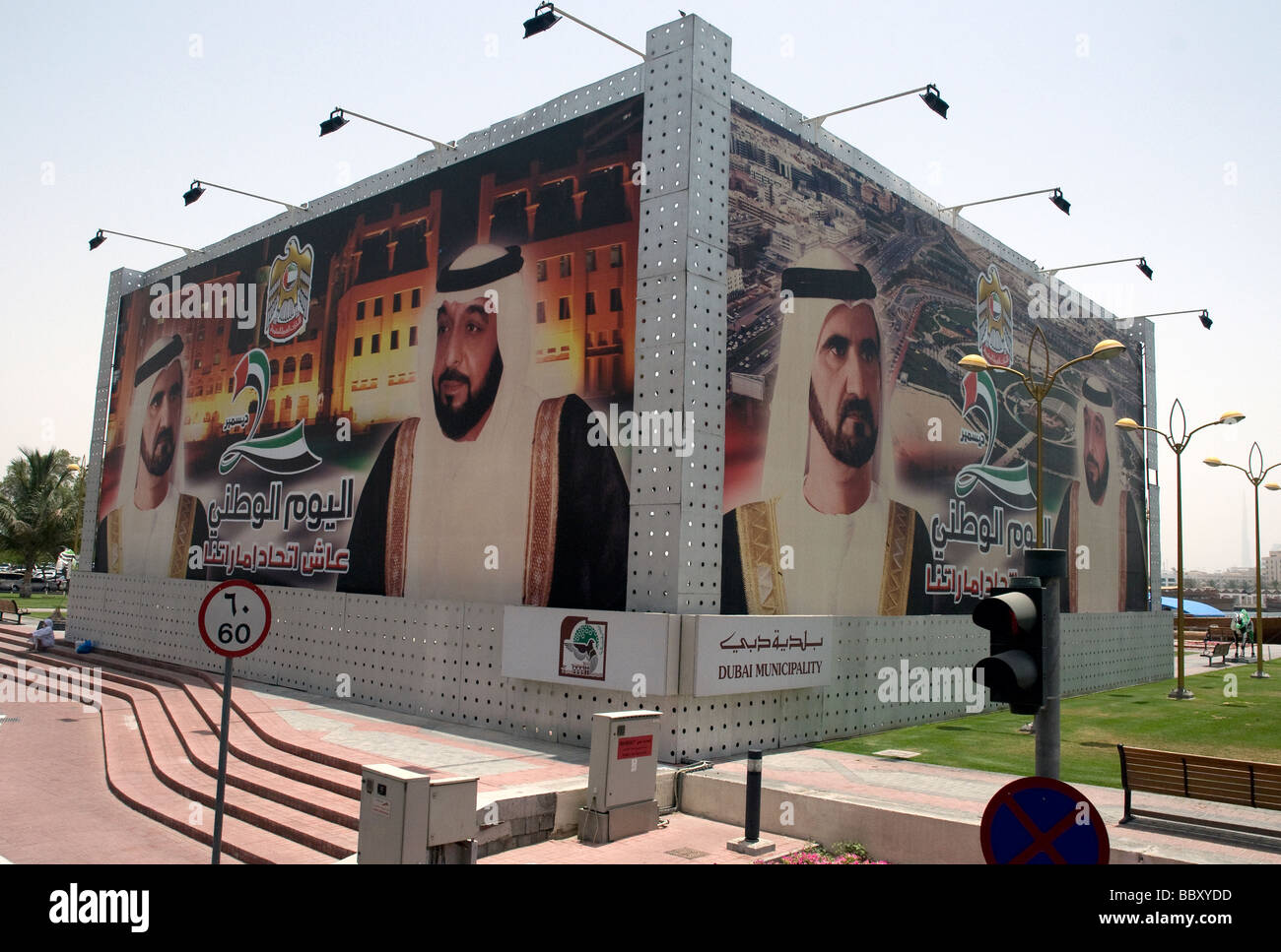 Dubai e la sua fiorente comune, come un cartellone proclama, sono dominate dalla sentenza al- Maktoum famiglia reale Foto Stock