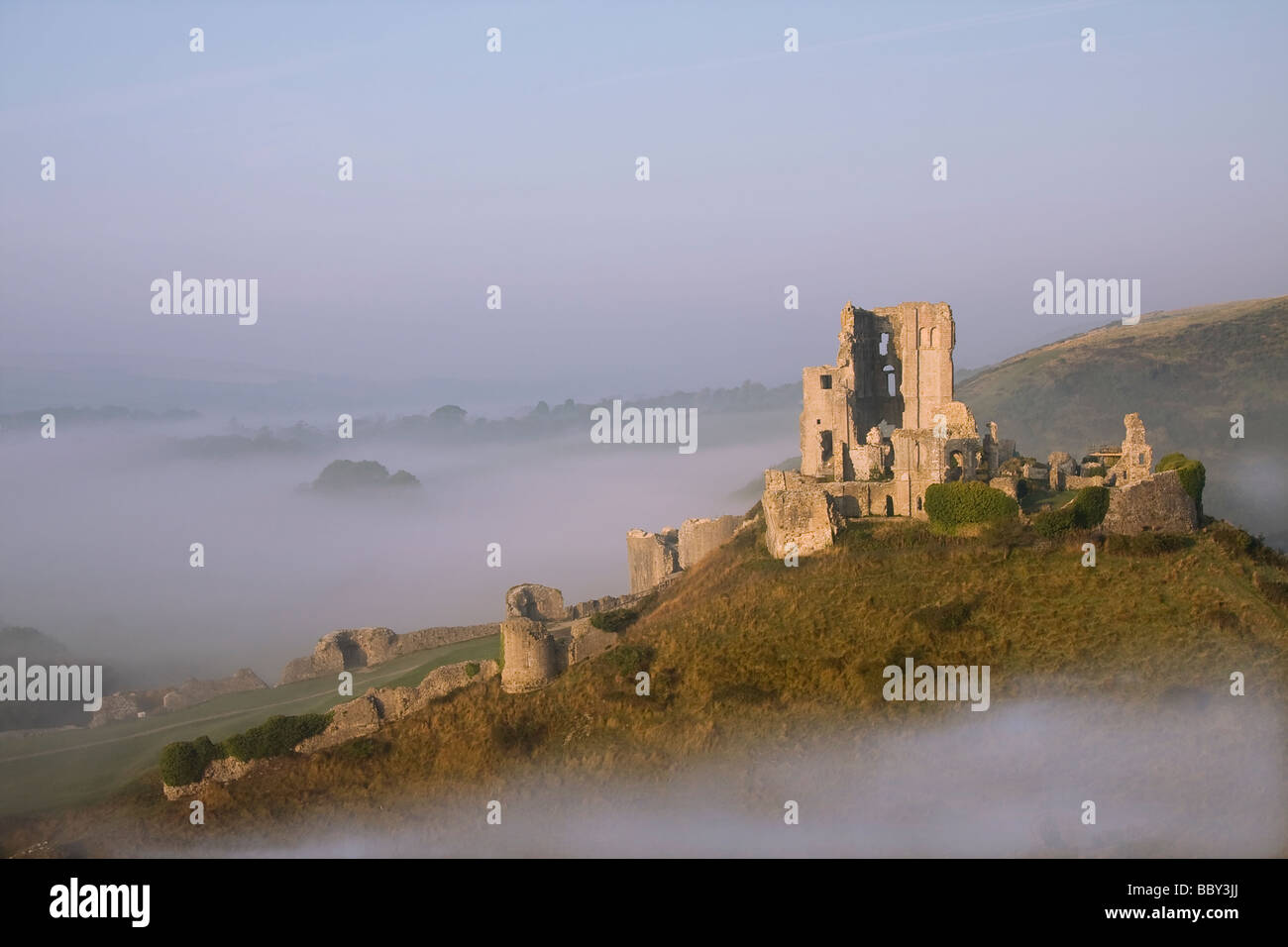 Corfe Castle in early morning mist, monumento storico, preso dalla distanza, Purbecks, Dorset Foto Stock