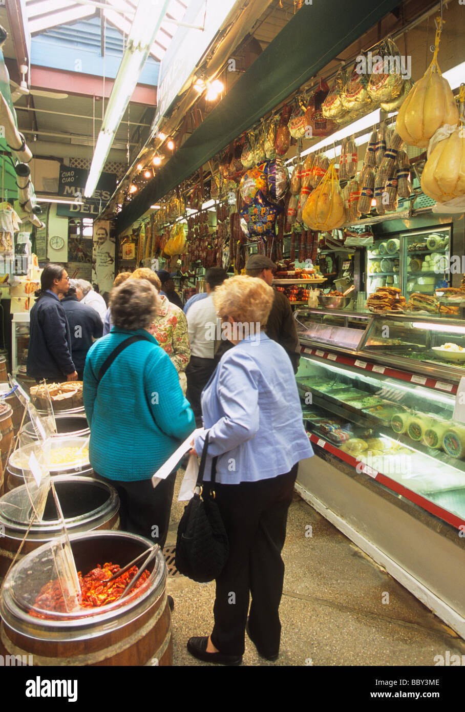New York City USA The Bronx Arthur Avenue, mercato della gastronomia, persone in attesa di essere servite. Cultura del consumatore Foto Stock