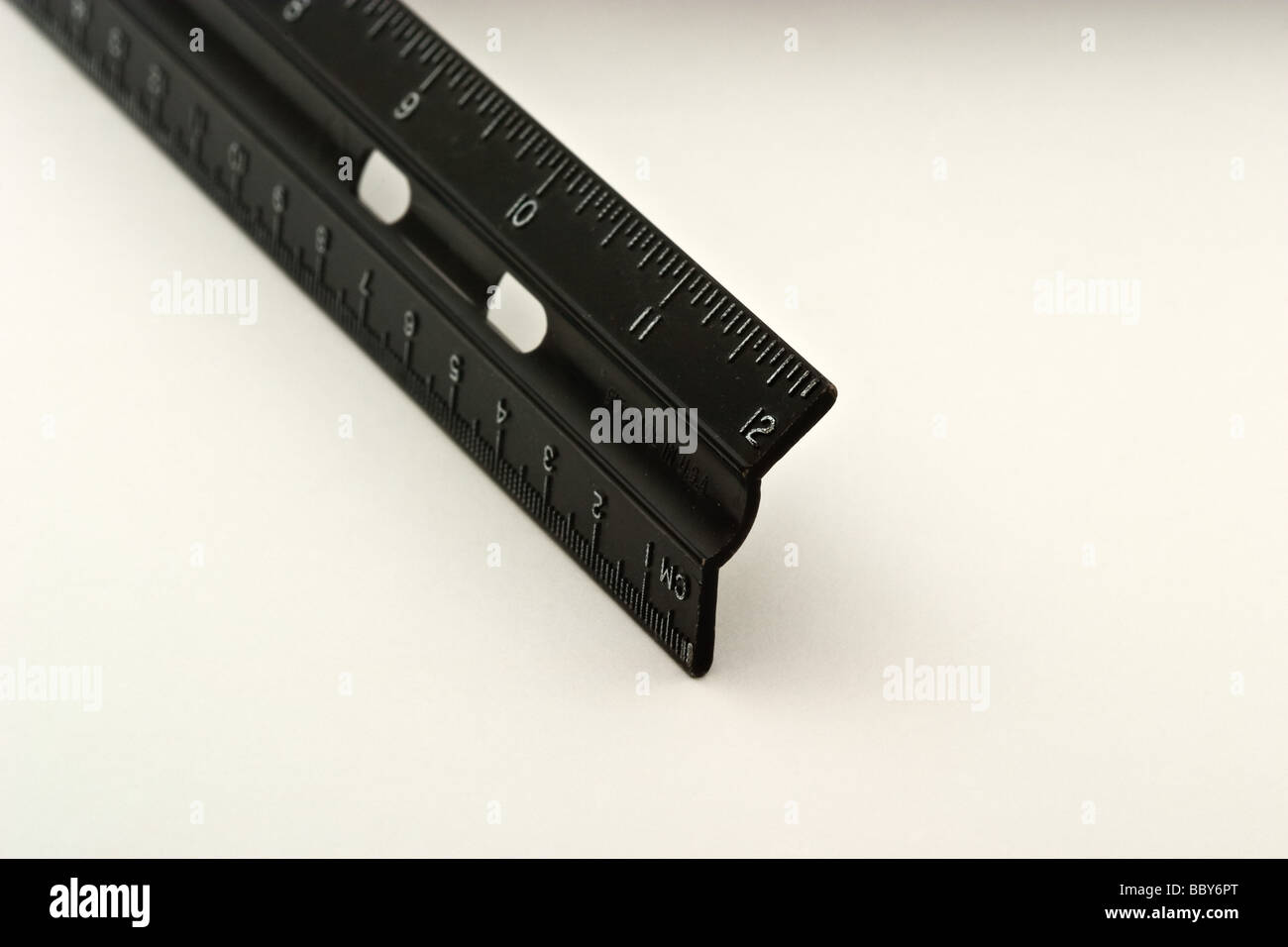 Fine di un nero righello di plastica che mostra i pollici e centimetri Foto Stock