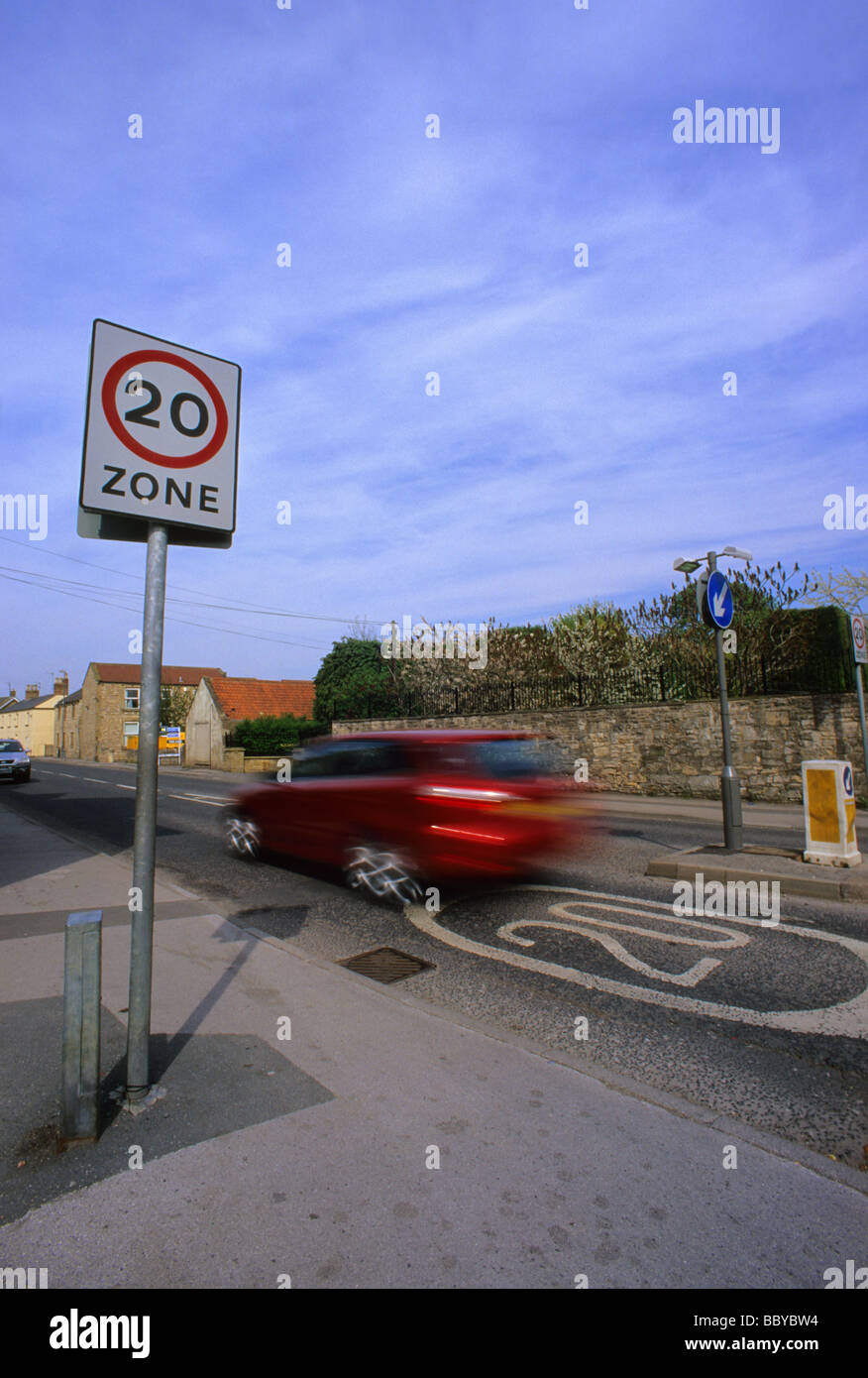 Auto passando a 20 miglia per ora il limite massimo di velocità zona segno di avvertimento sulla strada attraverso il villaggio nei pressi di Leeds Yorkshire Regno Unito Foto Stock