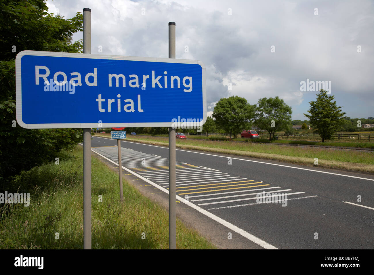 La segnaletica stradale trial cartello stradale e marcature sulla strada a doppia carreggiata County Antrim Irlanda del Nord Regno Unito Foto Stock