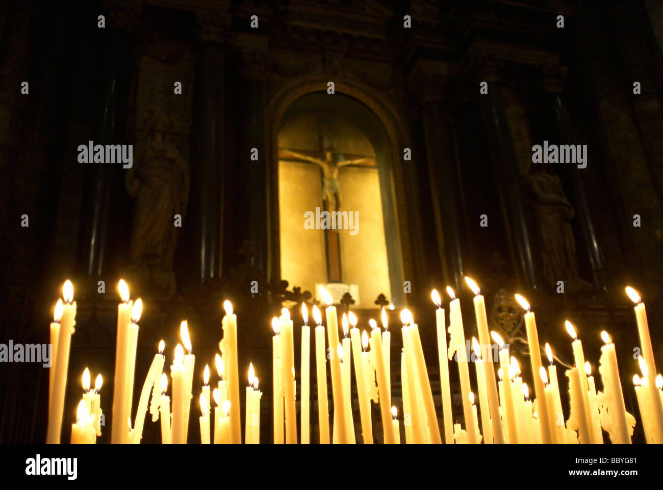 Candele votive a bruciare in una chiesa Foto Stock