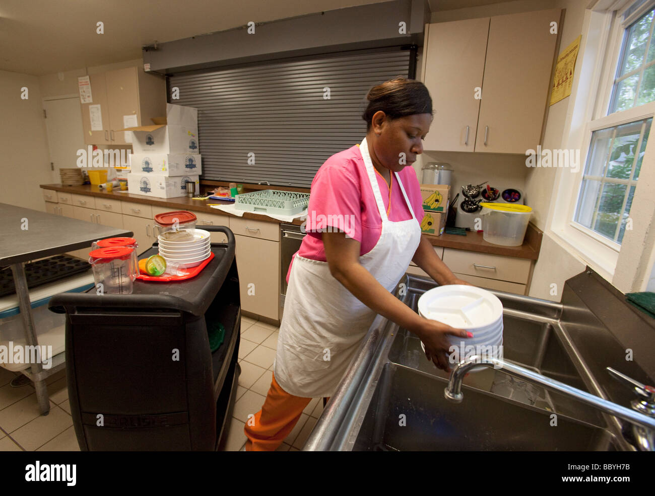 Biloxi Mississippi un lavoratore lava piatti a un centro di cura dei bambini operati da Moore comunità Casa Foto Stock