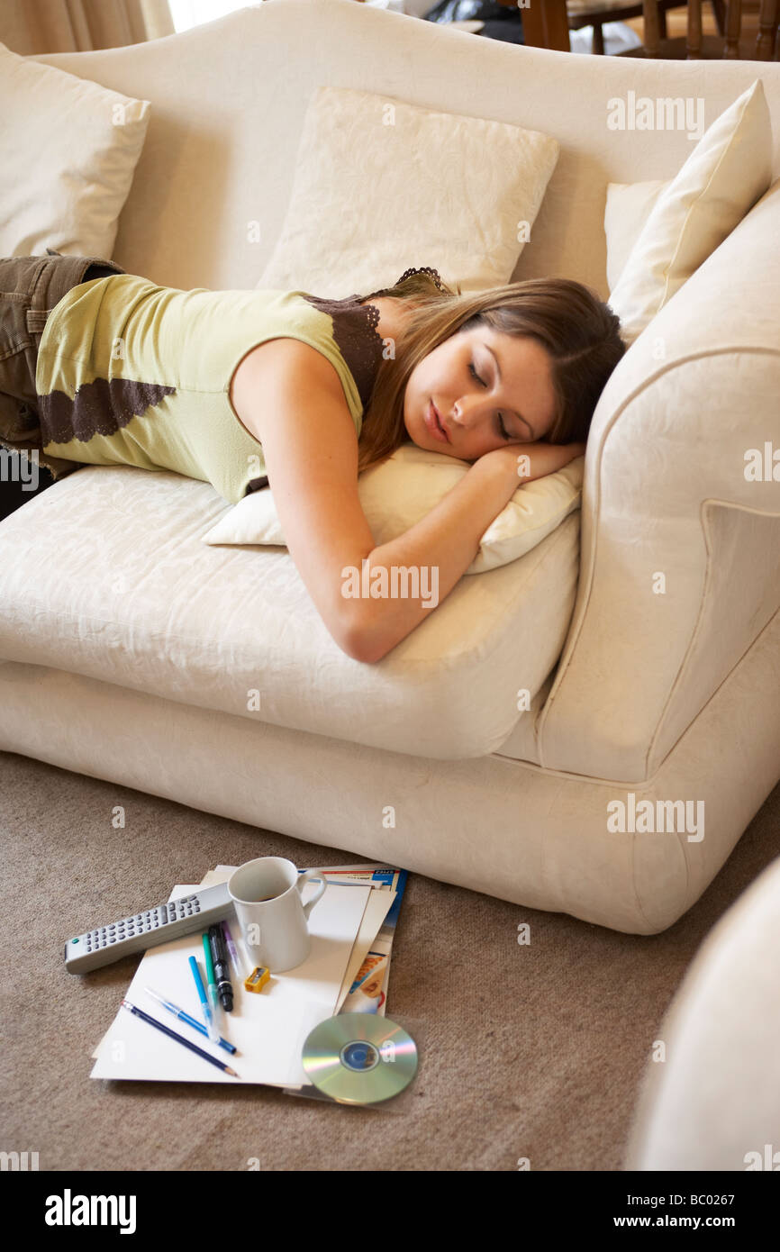 Giovane donna addormentata su un divano Foto Stock