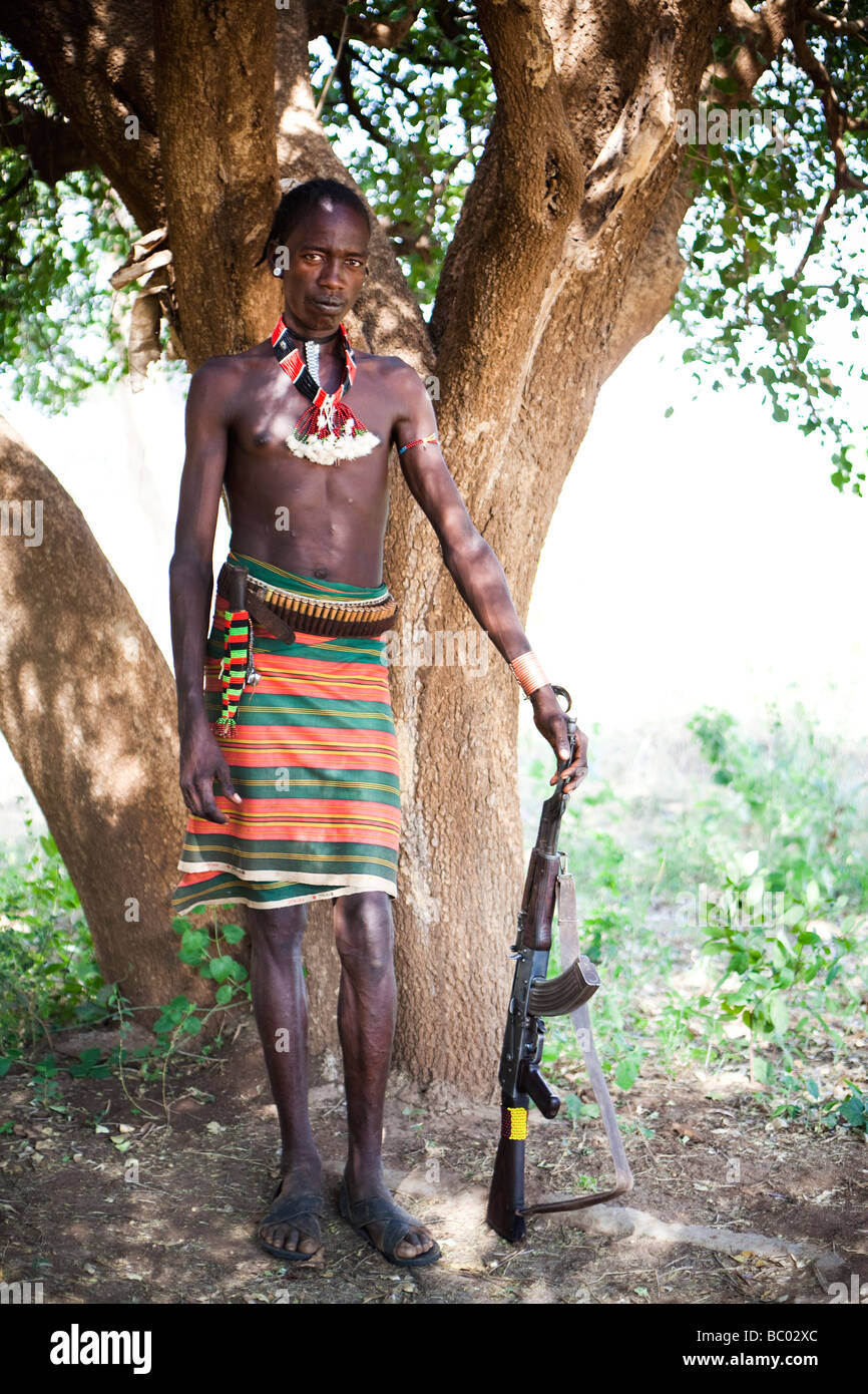 Un giovane uomo si erge con un kalashnikov in remoto la Hamer villaggio nella valle dell'Omo, Etiopia. Foto Stock