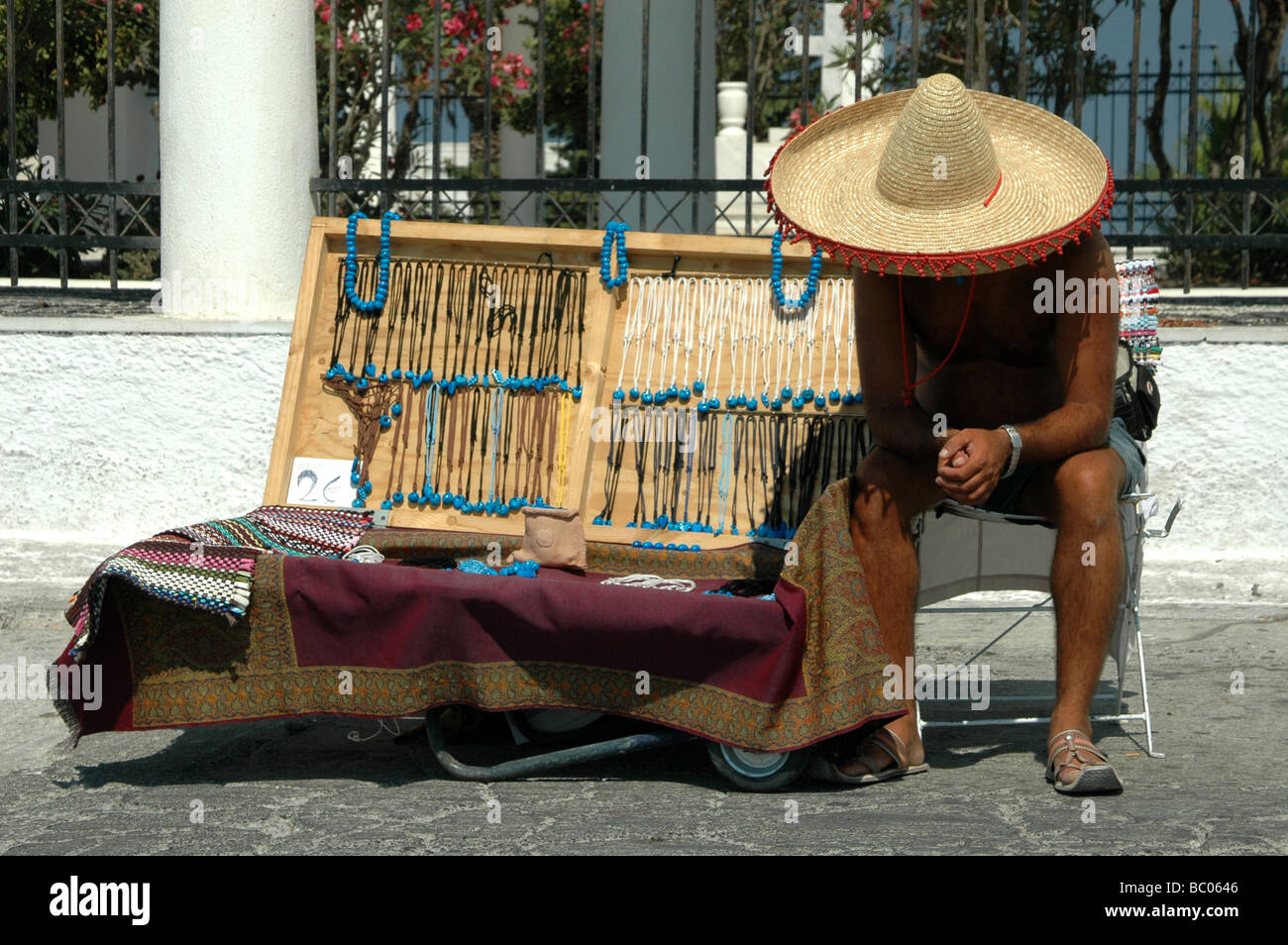 Commerciante di strada con un sombrero che vende gioielli a Fira sull'isola greca di Santorini nel Mar Egeo Foto Stock