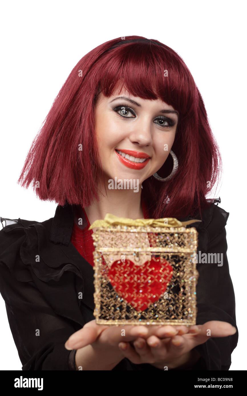 Bella Donna sorridente con cuore imballate in una golden confezione regalo nella sua mano Shallow DOF focus sulla faccia Foto Stock